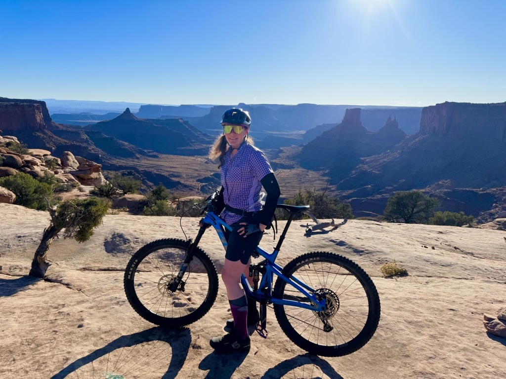 Michelle with her mountain bike on slickrock above canyon country